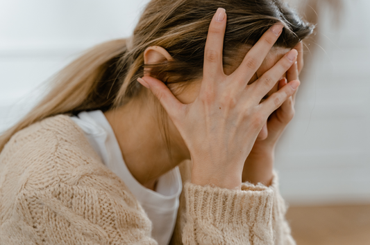 Distraight woman holding her head in her hands